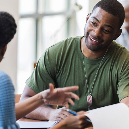 Military student sitting across a table from an advisor